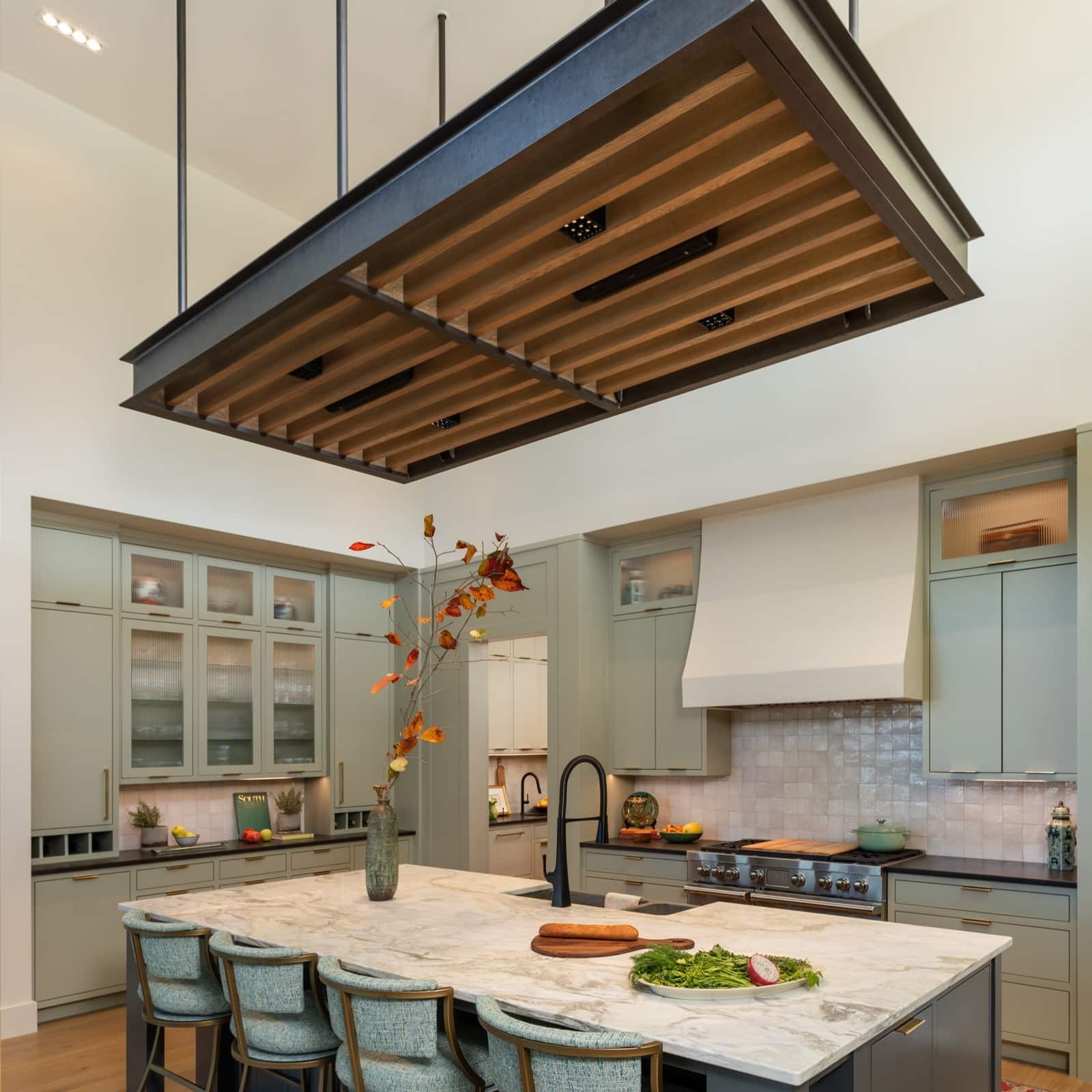 Sage kitchen with glass-front uppers, paneled refrigerator and a plaster hood